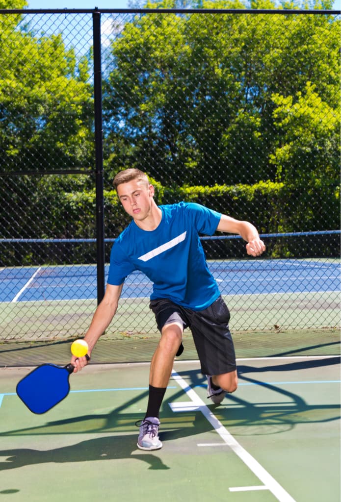 This is a photo of a pickleball court and a man playing pickleball.