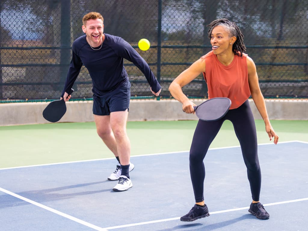 This is a photo of two people playing pickleball on a newly constructed court.